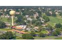 Community aerial view showcasing a pool, clubhouse, and golf course amidst lush trees at 1146 W Boone Ct, Lady Lake, FL 32159