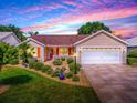 Charming single-story home featuring a well-manicured lawn, tasteful landscaping, and a two-car garage at 1206 Thompson Ave, The Villages, FL 32162