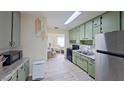 Well-lit kitchen featuring wooden floors, classic green cabinets, granite counters, and stainless steel appliances at 1224 Lakeview Dr, Clermont, FL 34711