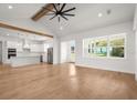 Open concept living room with vaulted ceiling, wood beam, and views to the kitchen at 12565 Cynthia Ln, Clermont, FL 34715