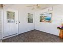 Inviting screened porch featuring neutral color walls, decorative art, and ceiling fan at 1615 Navidad St, The Villages, FL 32162