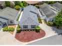 An aerial view of a well-maintained single-story home with a manicured yard and a private setting at 1713 Jadestone Ter, The Villages, FL 32162