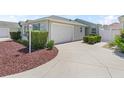 A well-maintained home with a charming exterior, featuring a manicured lawn and a convenient attached garage at 1713 Jadestone Ter, The Villages, FL 32162