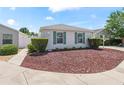 A charming single-story home showcasing a well-manicured front yard with vibrant, low-maintenance landscaping at 1713 Jadestone Ter, The Villages, FL 32162