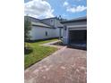 Exterior shot with brick driveway leading to a two-car garage and a well-maintained lawn at 1808 Carnostie Rd, Winter Haven, FL 33884