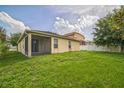 Spacious backyard featuring a lush green lawn, enclosed porch, and a partial white fence at 236 Savannah Preserve Loop, Davenport, FL 33837