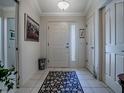 Bright foyer with tile flooring, decorative rug, and crown molding at 3112 Burbank Ln, The Villages, FL 32162