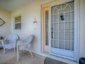 Inviting front porch with decorative door and white wicker chairs at 3112 Burbank Ln, The Villages, FL 32162