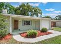 Exterior showcasing manicured lawn, mulch, and attached garage at 315 W 11Th Ave, Mount Dora, FL 32757