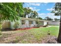 Landscaped front yard with healthy lawn, flowering shrubs, and partial fence at 315 W 11Th Ave, Mount Dora, FL 32757