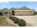 Inviting home exterior showcasing a manicured lawn, decorative driveway, and a convenient two-car garage at 3411 Eisenhower Way, The Villages, FL 32163
