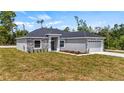 Attractive home featuring stone veneer, neutral paint, attached garage, and landscaping at 40685 E Ninth Ave, Umatilla, FL 32784