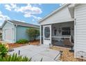 Inviting screened front porch with comfortable seating, decorative elements, and a view of the landscaped yard at 412 Hildalgo Dr, The Villages, FL 32159