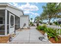 Beautifully landscaped front yard with concrete walkway, decorative garden features, and lush greenery at 412 Hildalgo Dr, The Villages, FL 32159