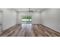 Spacious living room with wood-look flooring and sliding glass doors leading to the backyard at 41346 Persimmon St, Eustis, FL 32736