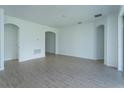 Bright and airy living room with wood-look tile flooring and arched doorways at 5013 Balsam Falls Rd, Deland, FL 32724
