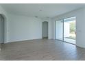 Spacious living room featuring wood-look tile flooring and sliding glass doors to the backyard at 5013 Balsam Falls Rd, Deland, FL 32724
