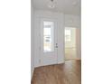 Bright foyer with wood-look tile floors and a clear view of the entry door at 5017 Balsam Falls Rd, Deland, FL 32724