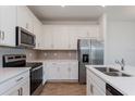 Close-up of a kitchen featuring stainless steel appliances, white cabinets and countertops at 5017 Balsam Falls Rd, Deland, FL 32724