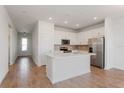 Open-concept kitchen featuring white cabinetry, stainless steel appliances, and center island at 5017 Balsam Falls Rd, Deland, FL 32724