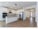 Open-concept kitchen with stainless steel appliances, a center island, white cabinets, and tile flooring at 5037 Balsam Falls Rd, Deland, FL 32724