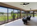 The screen lanai boasts relaxing seating, ceiling fans, and a great view of a pond at 5944 Hickey Way, The Villages, FL 32163