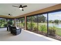The screened lanai has a ceiling fan and a beautiful view of the yard and a pond at 5944 Hickey Way, The Villages, FL 32163