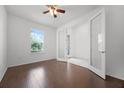 Bright bedroom with wood floors, ceiling fan and a window with a view of palm trees at 780 Mystic Hill Ct, Kissimmee, FL 34759