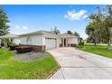 Charming home with a well-maintained lawn, an inviting front door, and an attached garage at 8608 Se 141St Street Rd, Summerfield, FL 34491