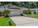 Lovely home with a spacious driveway, well-maintained lawn, and beautiful landscaping at 8705 Village Green Blvd, Clermont, FL 34711