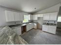 Modern kitchen featuring white cabinets and granite countertops, ready for appliances at 919 Cr 482C, Lake Panasoffkee, FL 33538