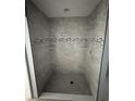 New bathroom shower with gray tile and a decorative accent stripe at 919 Cr 482C, Lake Panasoffkee, FL 33538