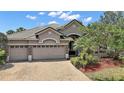 Well-maintained single-story home featuring a paver driveway, three-car garage, and beautiful landscaping at 926 Wood Briar Loop, Sanford, FL 32771