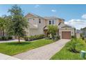Beautiful two-story home with well-manicured landscaping, a brick driveway, and inviting curb appeal at 1539 Osprey View Dr, Apopka, FL 32703