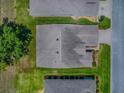 Aerial view of a single-Gathering home featuring a gray roof, green lawn, and proximity to neighboring houses at 1016 Eagles Lndg, Leesburg, FL 34748