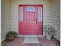 Inviting front door with sidelights, potted plants, and a brick walkway creating a warm entrance at 1016 Eagles Lndg, Leesburg, FL 34748