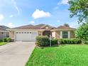 Traditional style home with a well manicured lawn and a 2 car garage at 10986 Se 171St Street Rd, Summerfield, FL 34491