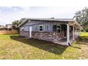 Exterior view showcases gray siding, brick detail, white trim, and partial view of green lawn at 110 River Beach Dr, Ormond Beach, FL 32176