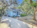 Inviting home exterior featuring a cozy screened porch, mature trees, and a well-maintained driveway at 1107 Northshore Dr, Eustis, FL 32726