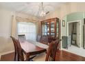 The dining room features hardwood floors, a large window with elegant curtains, and a decorative china cabinet at 11437 Alameda Sandra Dr, Clermont, FL 34711