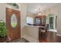 Interior view showcases the foyer with an ornate glass door, wood floors, and dining room with china cabinet at 11437 Alameda Sandra Dr, Clermont, FL 34711