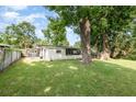 Spacious backyard featuring a lush lawn, mature trees, and a screened porch at 121 Mason Park Dr, Daytona Beach, FL 32117