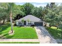 Beautiful well maintained home with lush green yard and long driveway at 1311 Rain Forest Ln, Minneola, FL 34715
