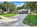 Beautifully landscaped home featuring a long driveway and mature trees at 1311 Rain Forest Ln, Minneola, FL 34715