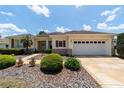 Lovely single-story home features a well-manicured lawn, lovely landscaping, and a two-car garage at 13165 Se 93Rd Cir, Summerfield, FL 34491