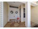 Inviting double door entry featuring a charming rocking chair and delightful wreaths at 13165 Se 93Rd Cir, Summerfield, FL 34491
