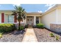 Inviting front entrance featuring a stone walkway, well-kept landscaping, and a charming front door with wreaths at 13165 Se 93Rd Cir, Summerfield, FL 34491