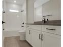Modern bathroom featuring tiled shower and floors, white cabinets and dark fixtures at 14261 Crest Palm Ave, Windermere, FL 34786