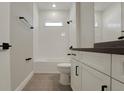 Modern bathroom featuring tiled shower and floors, white cabinets and dark fixtures at 14261 Crest Palm Ave, Windermere, FL 34786