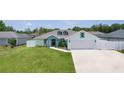 A nicely landscaped single-Gathering home with a well-maintained lawn and long driveway leading to a two-car garage at 15022 Se 94Th Ct, Summerfield, FL 34491